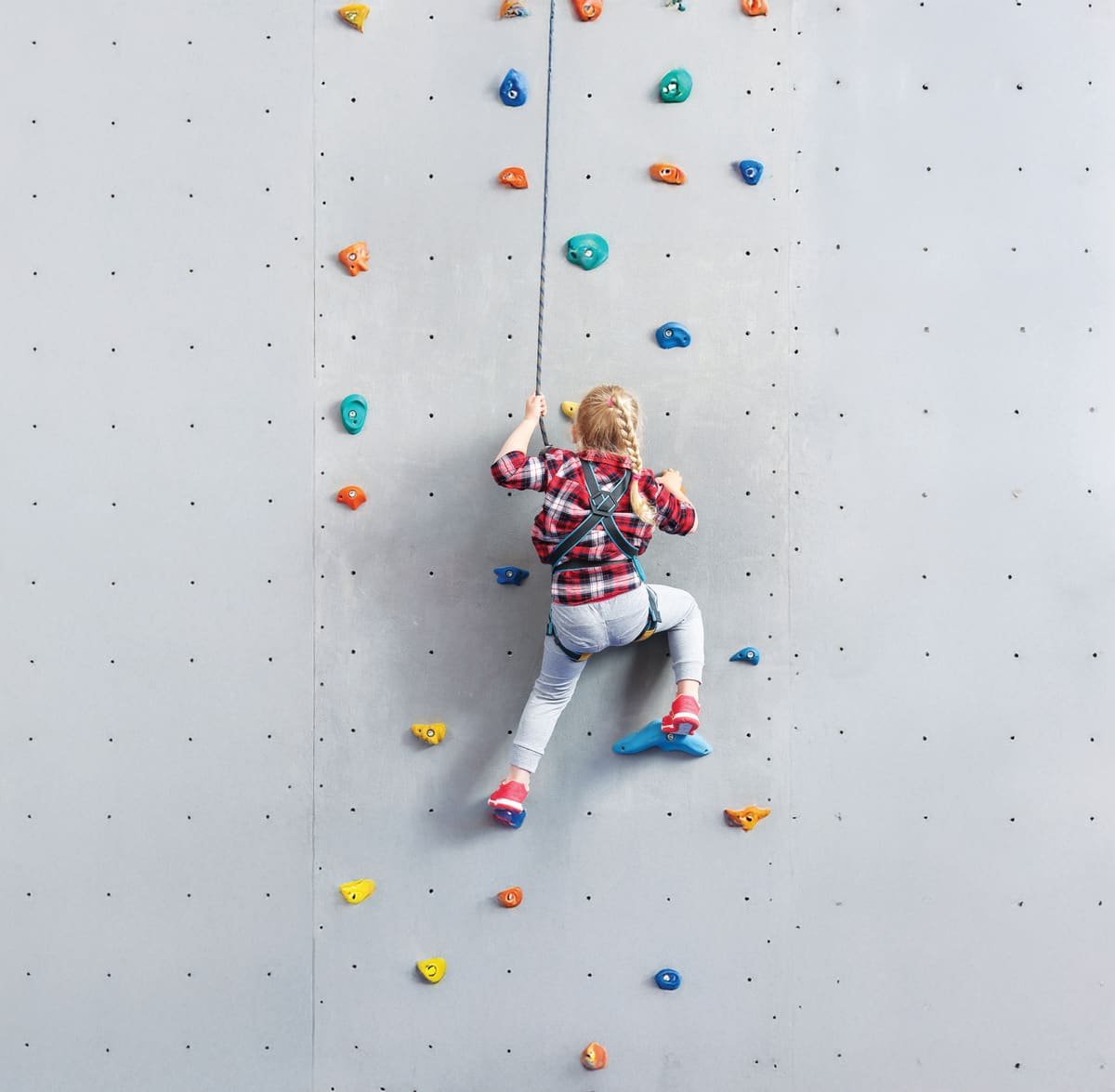 Child on a climbing wall in the Kids' Zone at Ashtech Presidential Towers